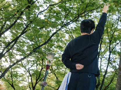 片手を挙げる男性